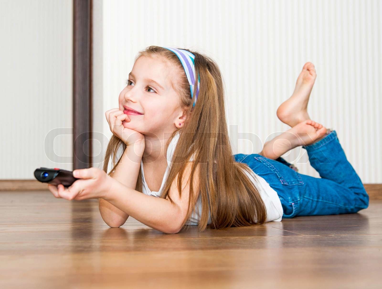 A Person With A Tattoo On Their Arm Holding A Remote Control In Front Of A Tv