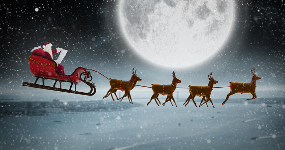 Side View Of Santa Claus Riding On Sleigh At Night Stock Photo